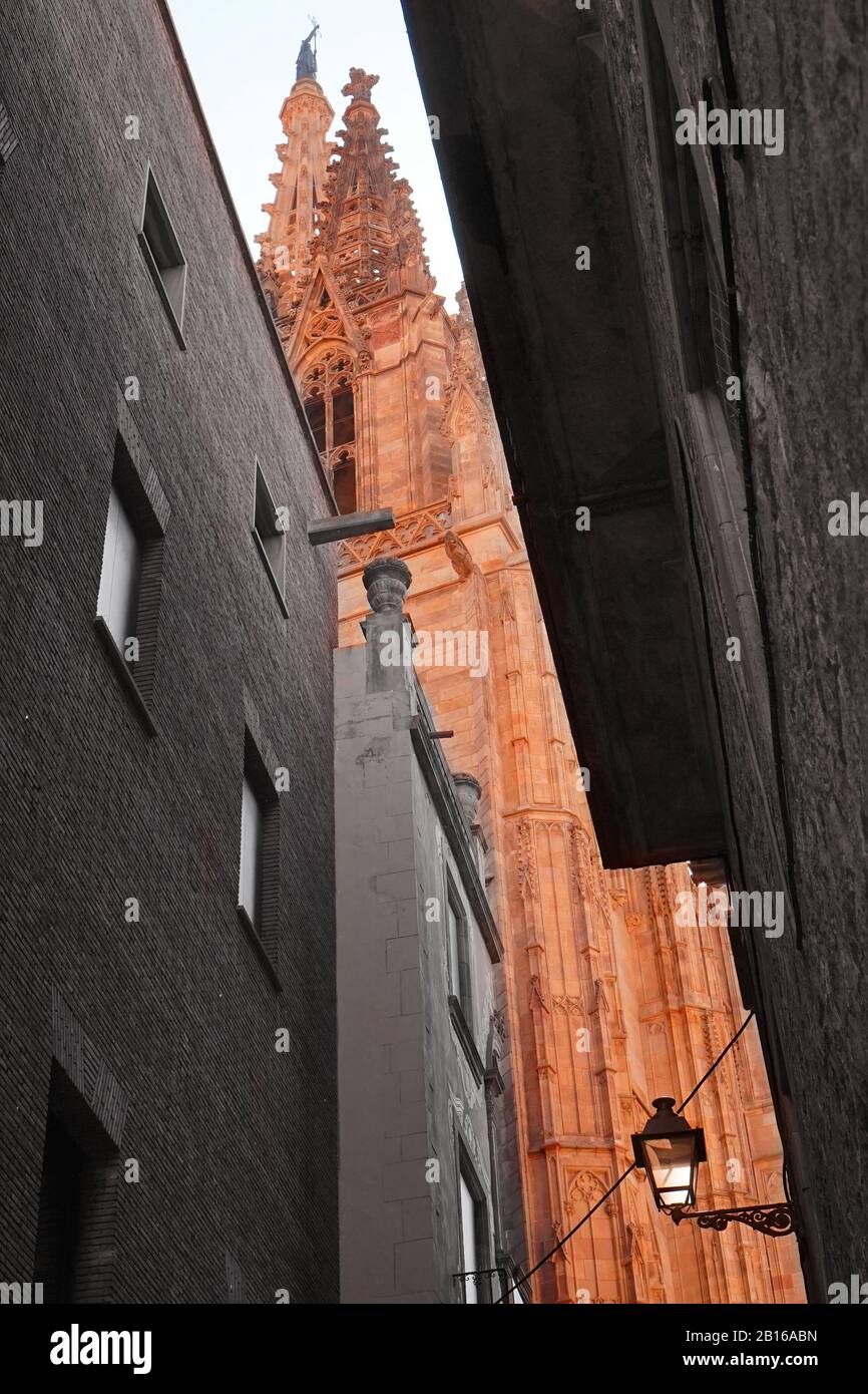 Image demi monochrome et demi-couleur regardant vers le haut à travers une rue étroite côté ville à une cathédrale catholique romaine Banque D'Images