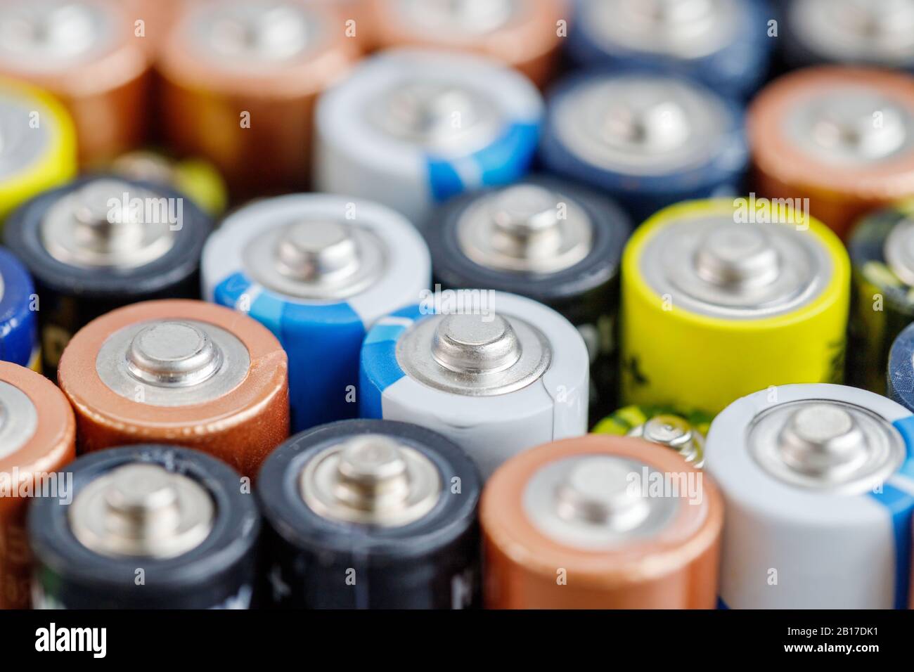 Gros plan sur les extrémités positives des batteries déchargées colorées de différentes tailles et de différents formats, . Concept de déchets dangereux Banque D'Images