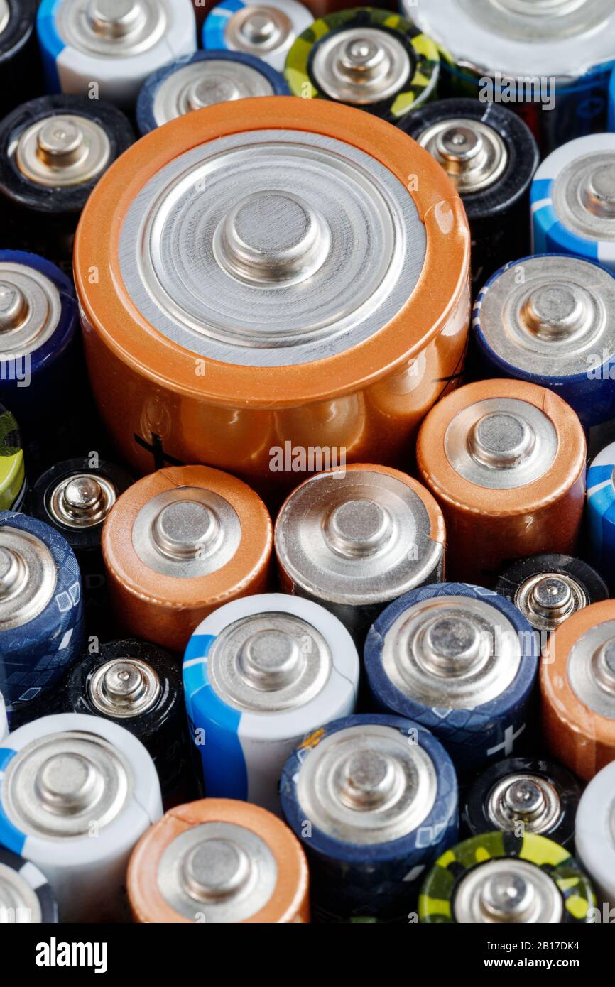 Gros plan sur les extrémités positives des batteries déchargées colorées de différentes tailles et de différents formats, . Concept de déchets dangereux Banque D'Images