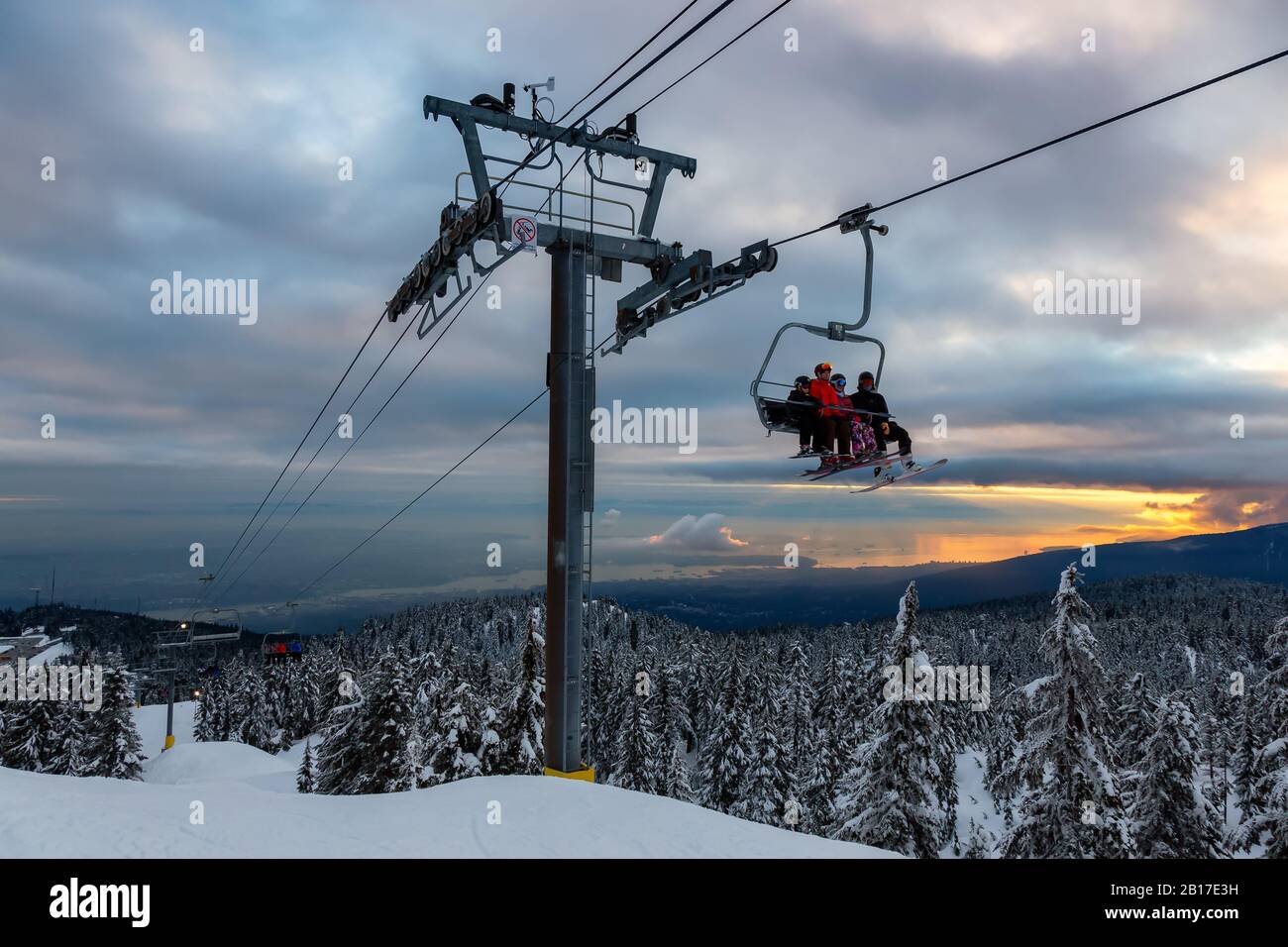 Seymour Mountain, North Vancouver (Colombie-Britannique), Canada - 12 février 2020 - télésiège jusqu'au sommet d'une station de ski sous un soleil ensoleillé et nuageux W Banque D'Images