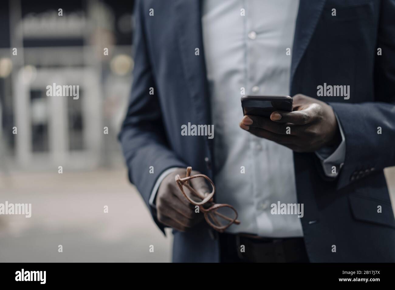 Vue panoramique sur les hommes d'affaires qui détiennent des lunettes et un smartphone Banque D'Images