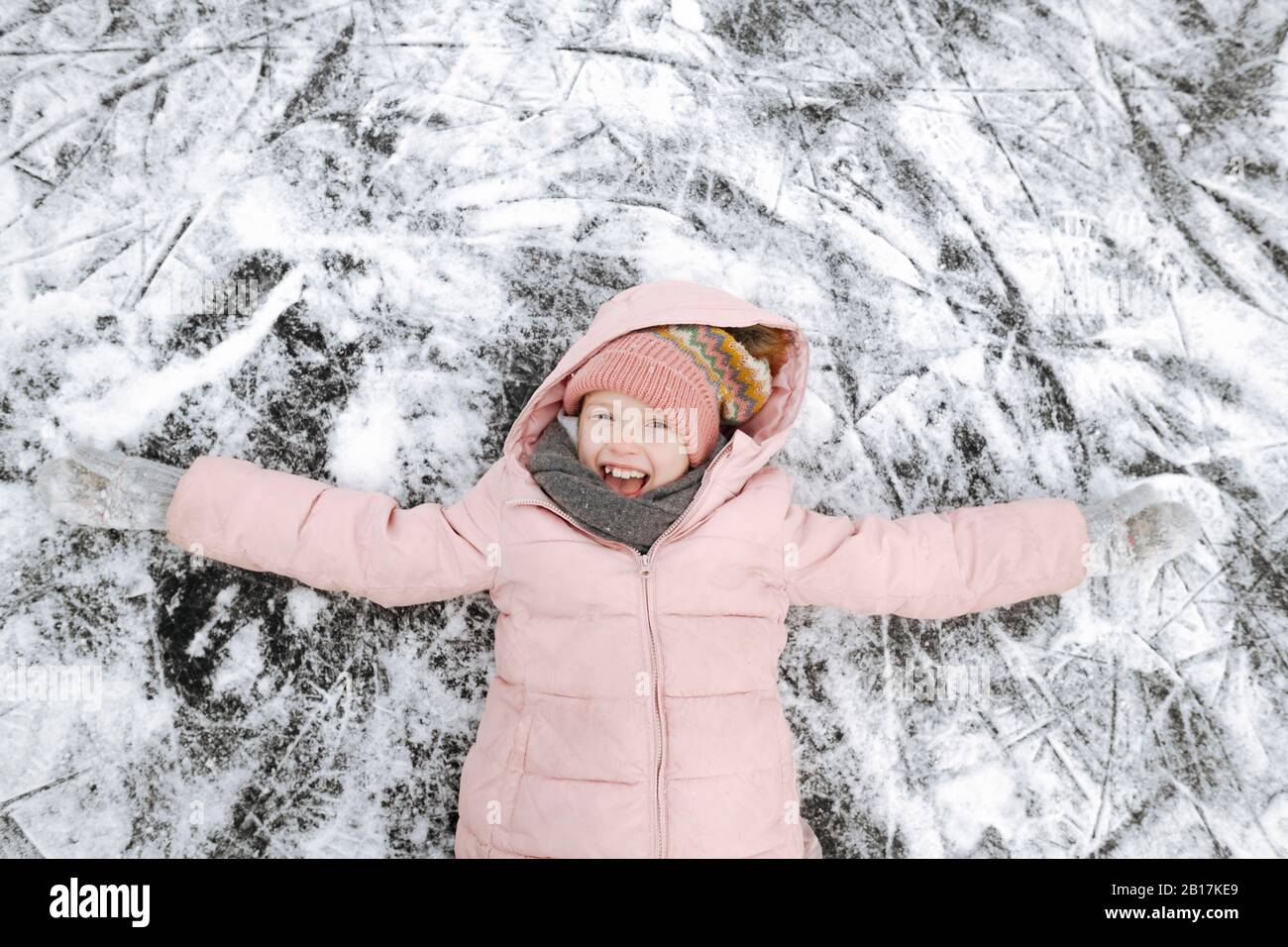 Portrait d'une jeune fille heureuse avec des bras étirés sur la glace Banque D'Images