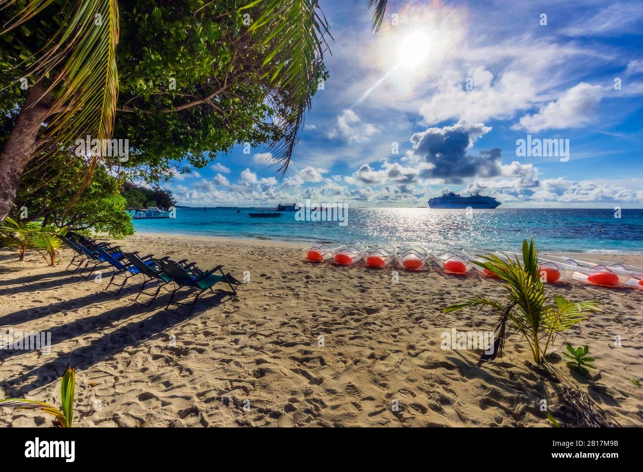 Papouasie-Nouvelle-Guinée, province de Milne Bay, rangées de chaises longues et de barques sur la plage de sable côtière en été Banque D'Images