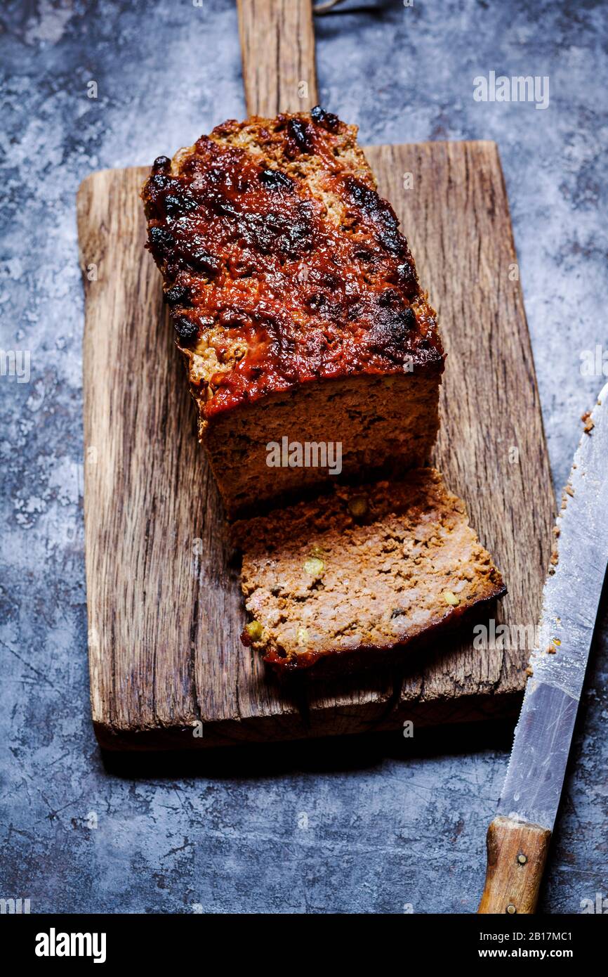 Pain de viande maison avec pois, herbes italiennes, tomates séchées et vitrage de ketchup Banque D'Images