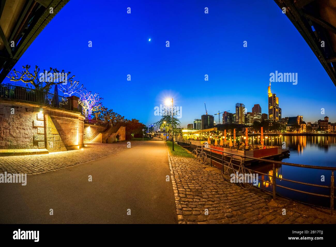 Allemagne, Hesse, Francfort, ciel dégagé sur une route de la ville vide au crépuscule avec horizon du centre-ville en arrière-plan Banque D'Images