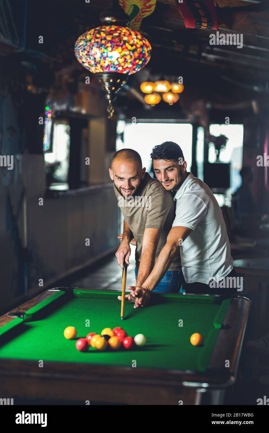 Couple gay jouant au billard ensemble dans un bar Banque D'Images