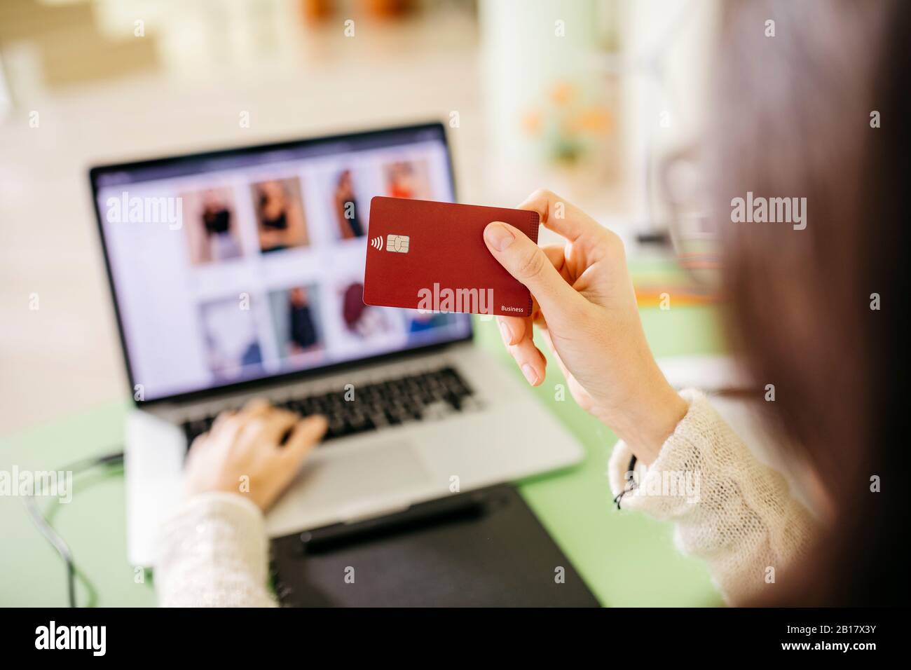 Gros plan d'une femme utilisant un ordinateur portable et une carte de crédit au bureau Banque D'Images