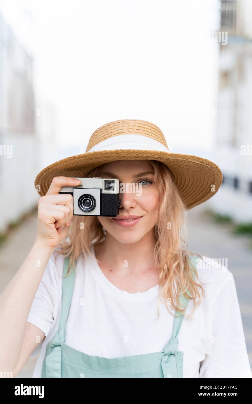 Portrait of smiling young woman with camera Banque D'Images