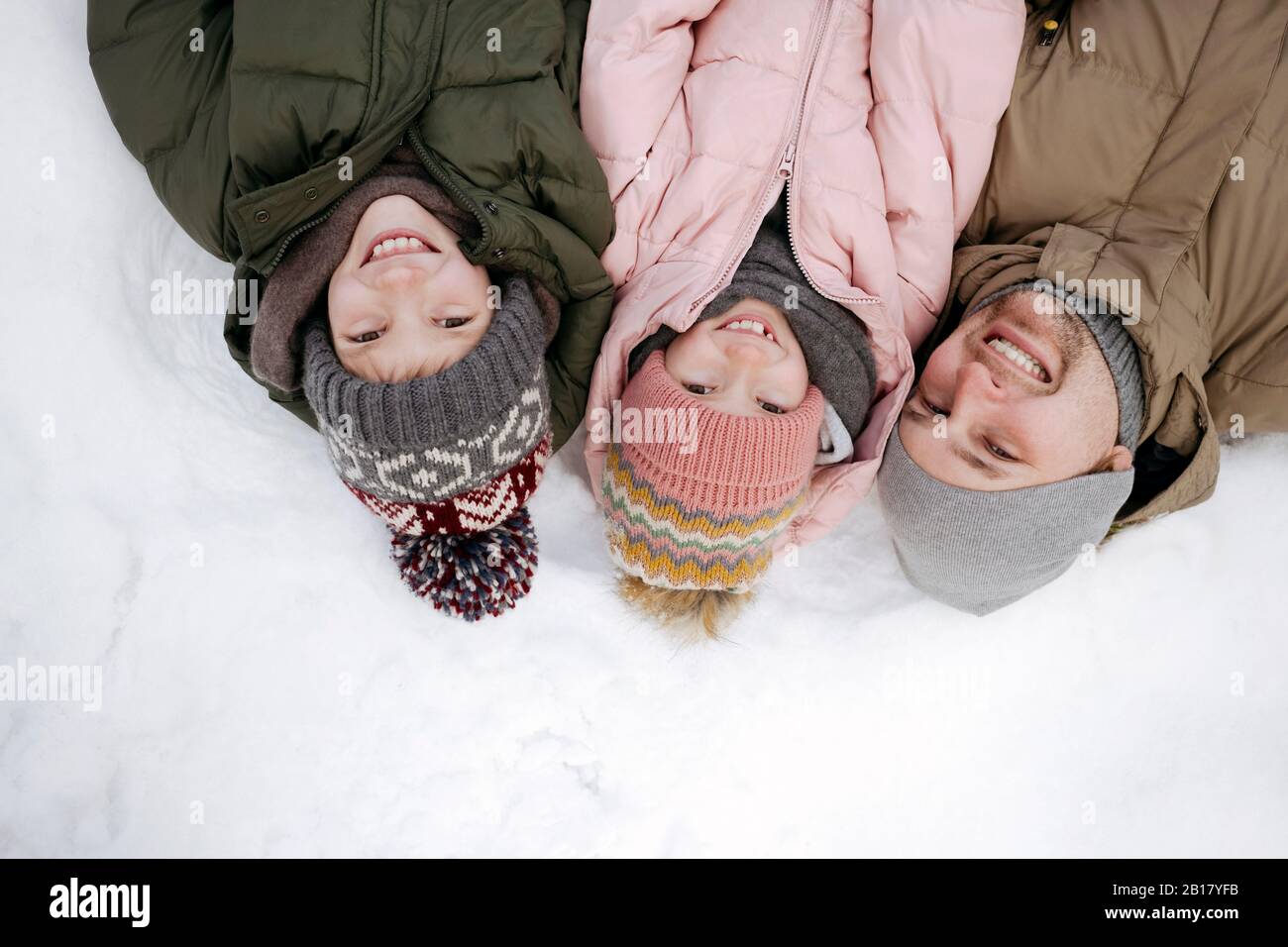 Portrait de famille du père et de deux enfants allongé sur la neige Banque D'Images