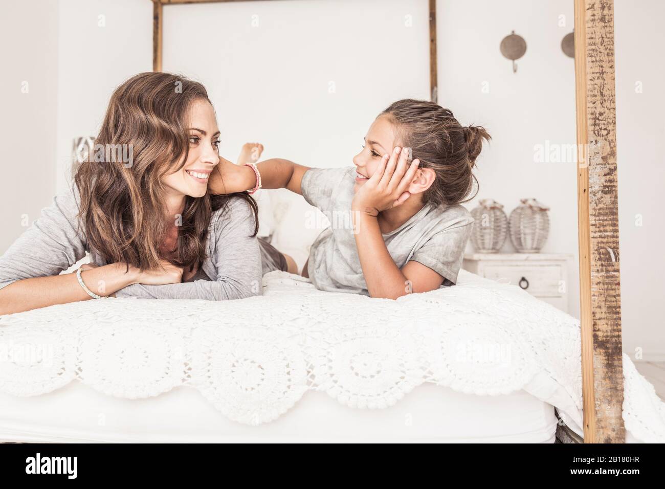 Mère et fille posée ensemble sur le lit se reposant Banque D'Images