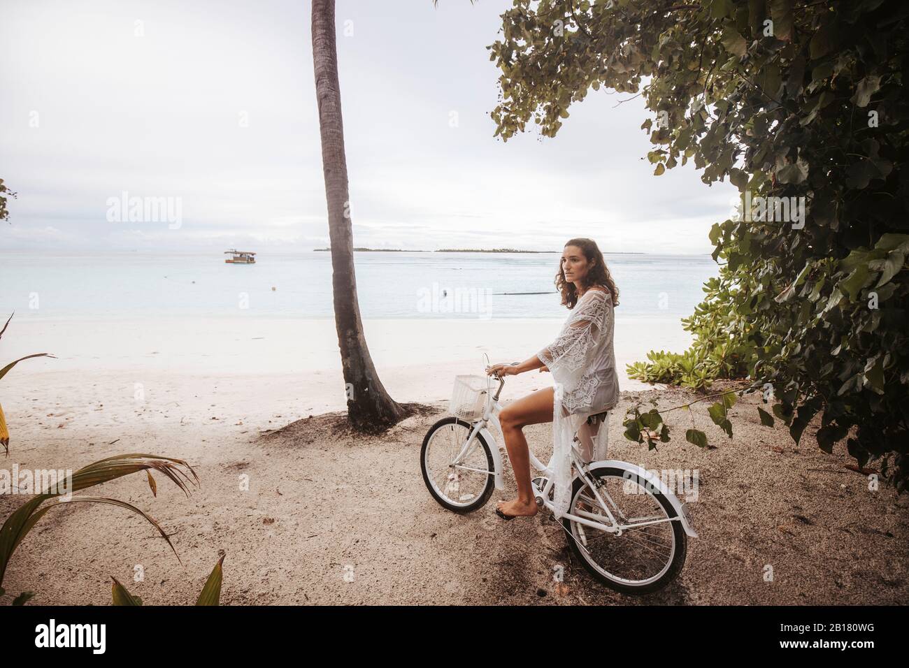 Femme avec vélo sur la plage, île Maguhdhuvaa, atoll Gaafu Dhaalu, Maldives Banque D'Images