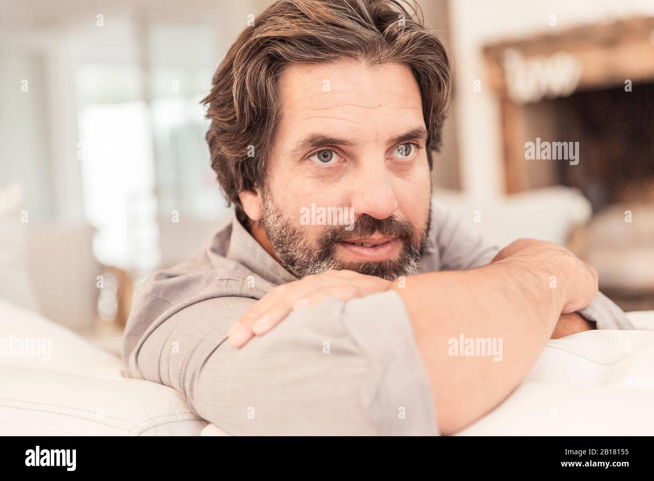 Portrait d'un homme barbu assis sur le canapé Banque D'Images