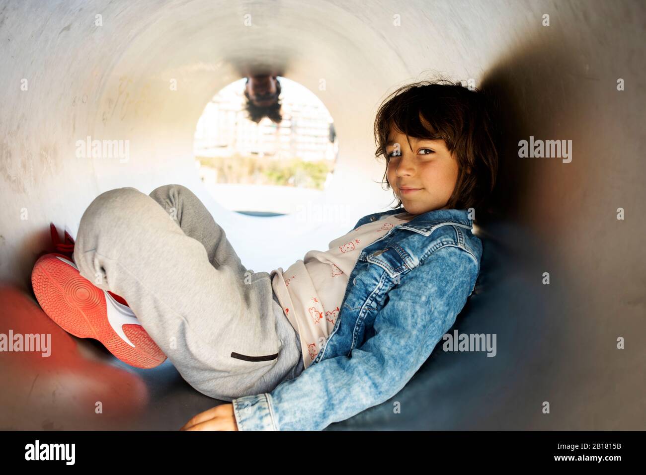 Portrait d'un petit garçon souriant dans un tube Banque D'Images