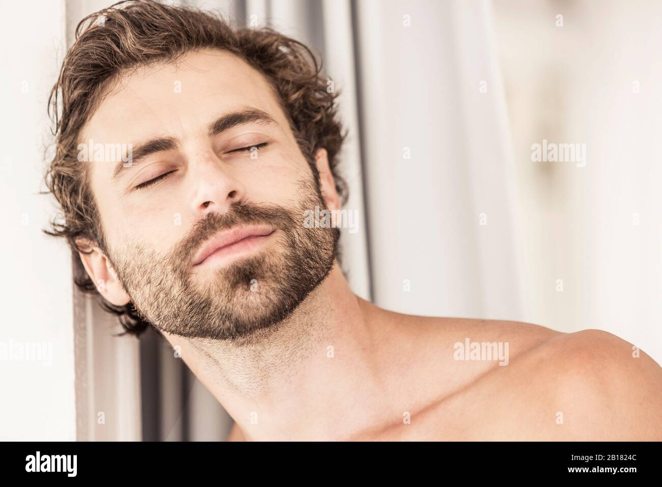 Portrait de jeune homme avec barbe, yeux fermés Banque D'Images