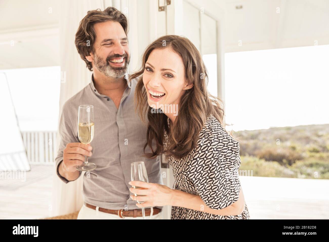 Un couple heureux buvant du champagne dans la maison de vacances Banque D'Images