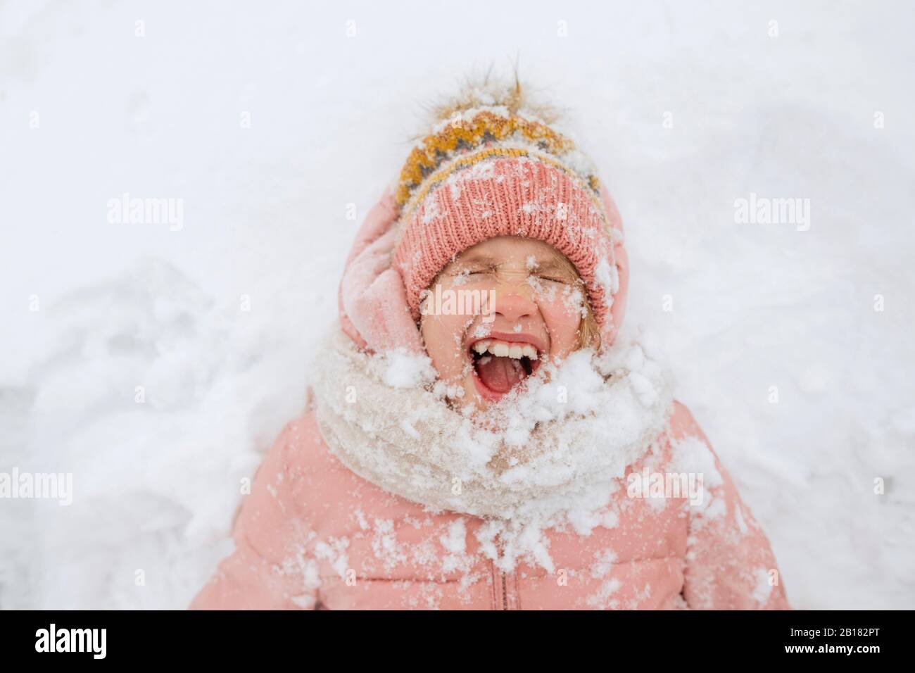 Portrait d'une fille hurlant posée sur la neige Banque D'Images