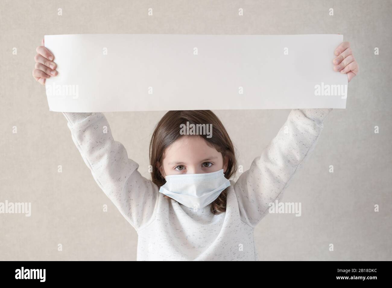 Danger infection danger COVID-19 2019-nCoV épidémie épidémie de quarantaine concept de petite fille dans le masque médical montrant slogan avec espace de copie Banque D'Images