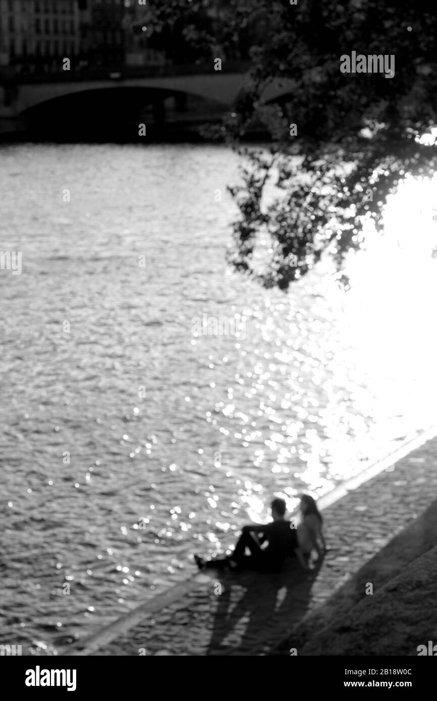 Paris, France. Vue Abstraite Floue Sur La Ville. Couple en amour Assis Le Long de la Seine. Banque D'Images