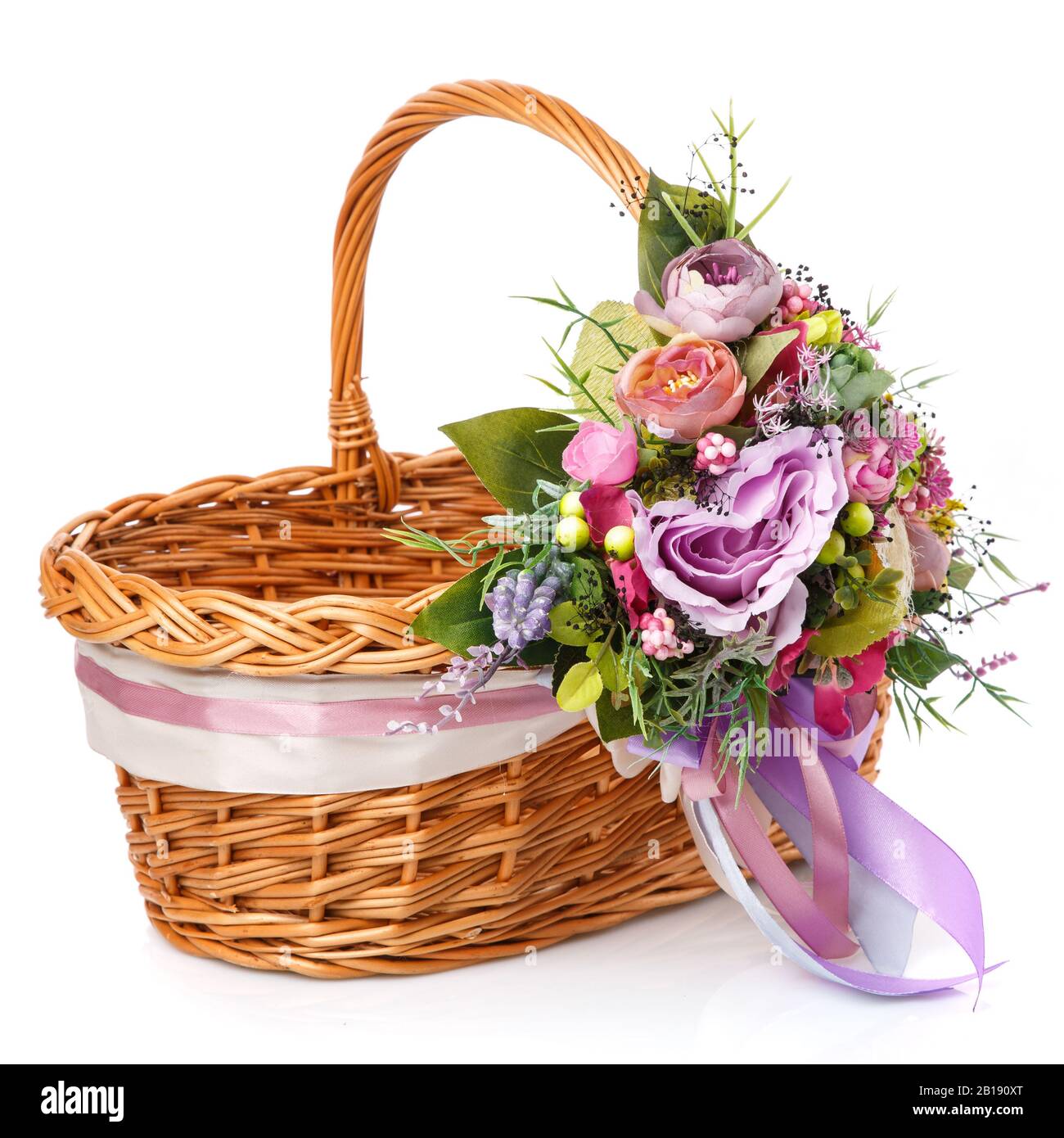 Panier en osier naturel avec fleurs et rubans. Magnifique noeud sur le côté. Isolé Banque D'Images