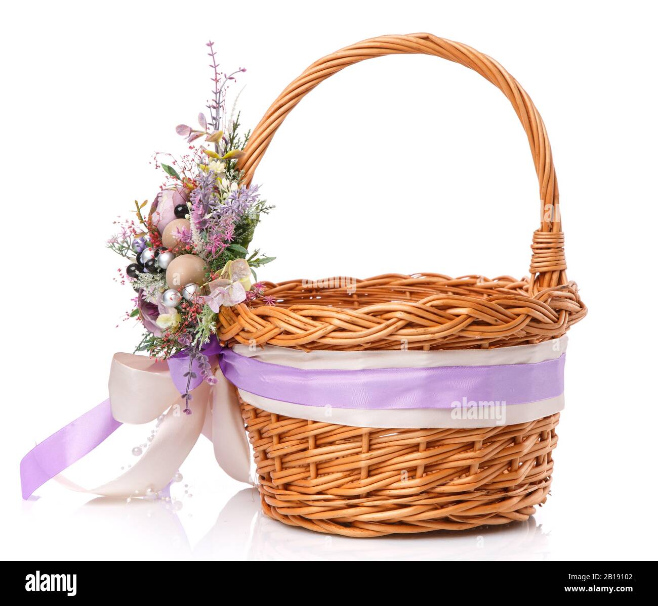 Panier en osier décoré de fleurs sur fond blanc Banque D'Images