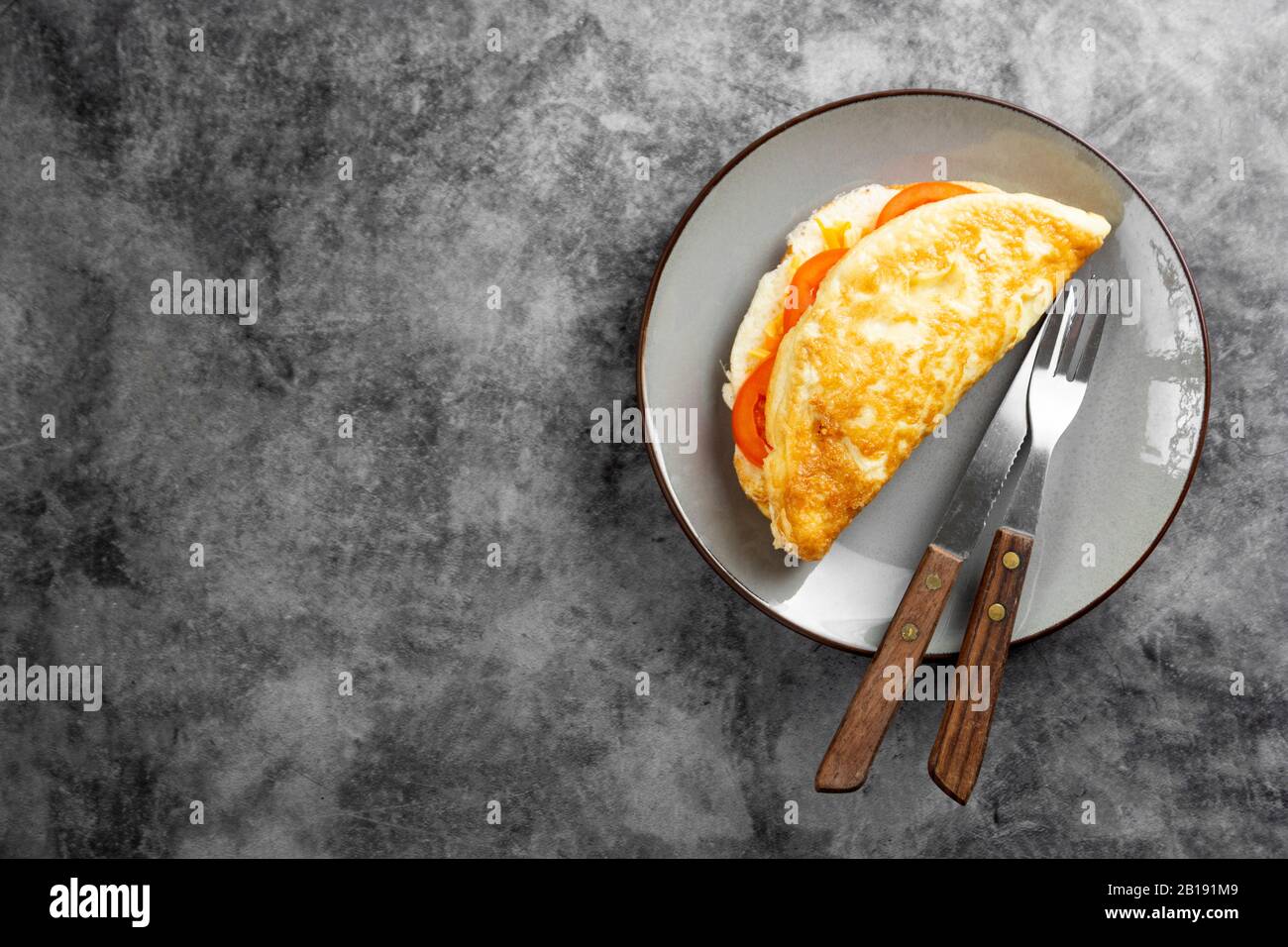 Omelette avec fromage et tomates pour le petit déjeuner. Vue sur le dessus avec espace de copie. Banque D'Images