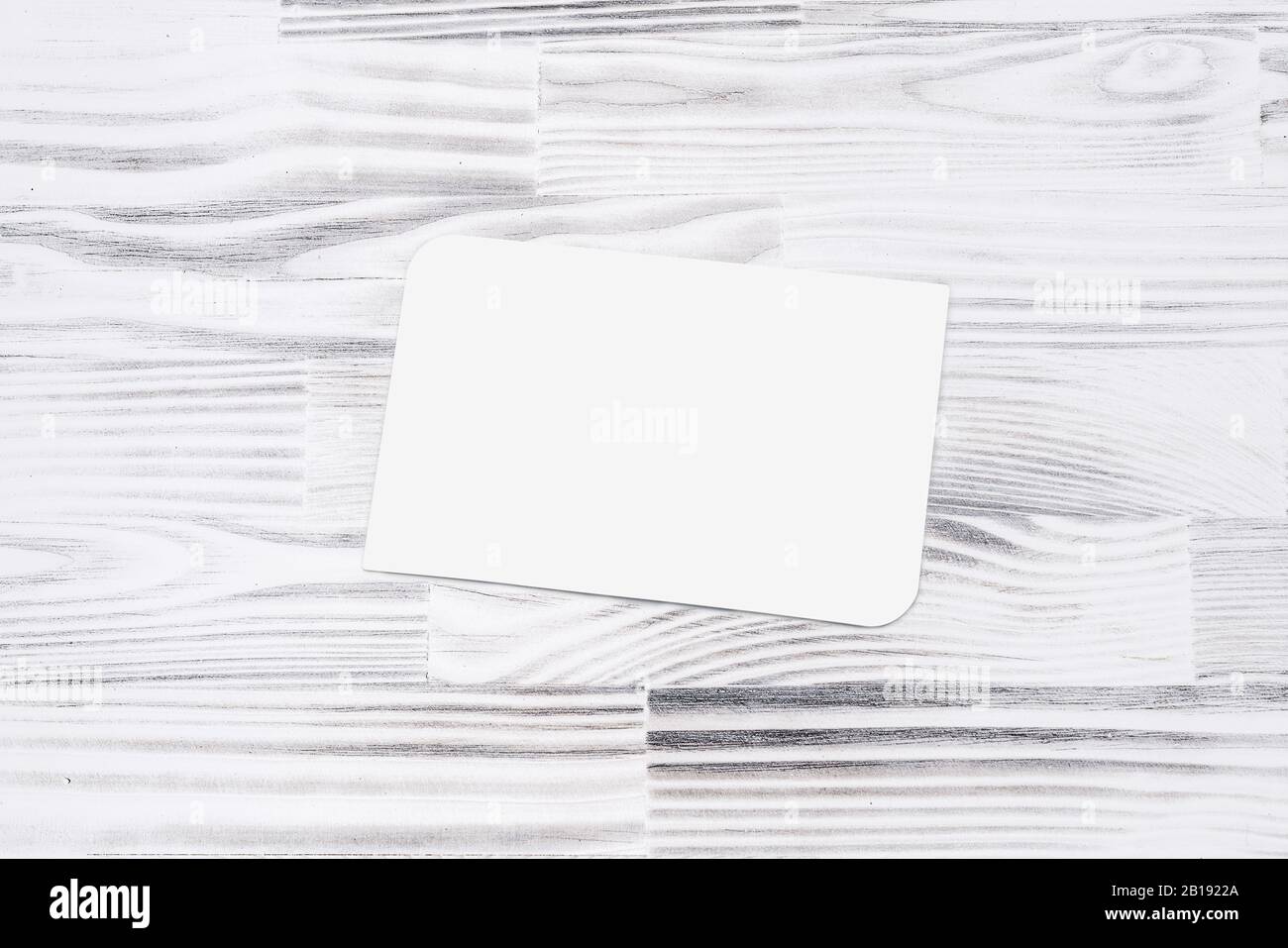 Carte de visite vide pour maquette sur fond de table en bois, isolée sur blanc Banque D'Images