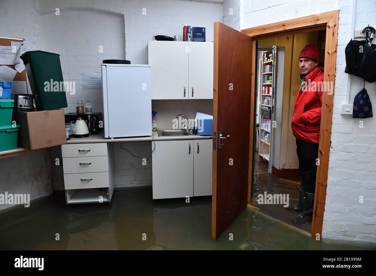 Martin Lunt voit les dommages dans sa pharmacie inondée, les Pharmacies Lunts, à Shrewsbury, comme d'autres avertissements d'inondation ont été émis en Angleterre et au Pays de Galles. Banque D'Images