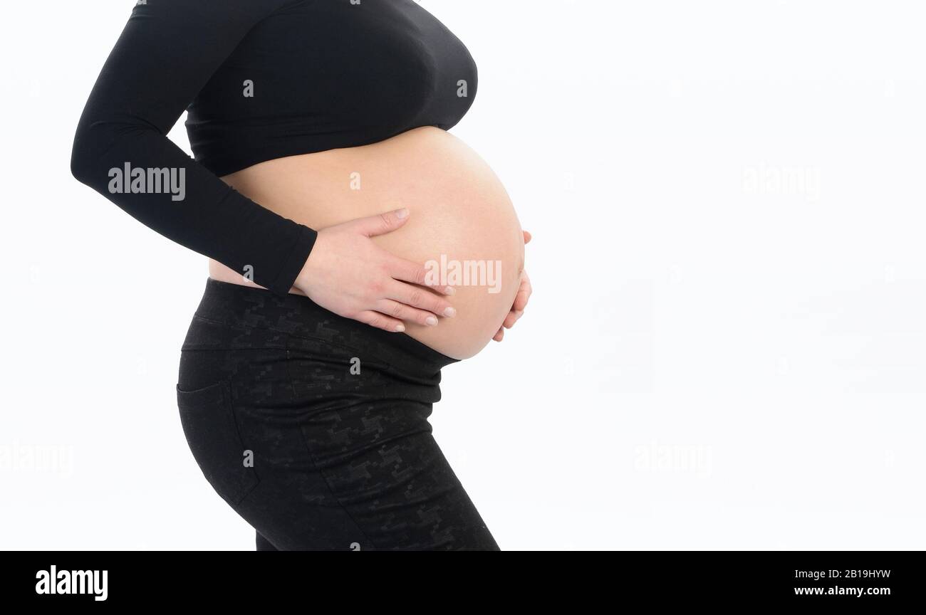 Femme enceinte avec les mains sur son ventre Banque D'Images