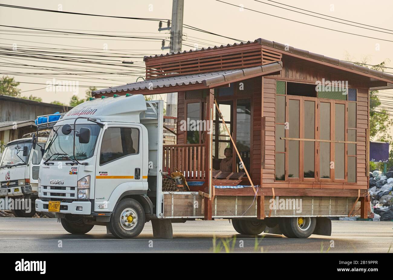 Une petite maison en bois étant transportée sur un camion. Banque D'Images