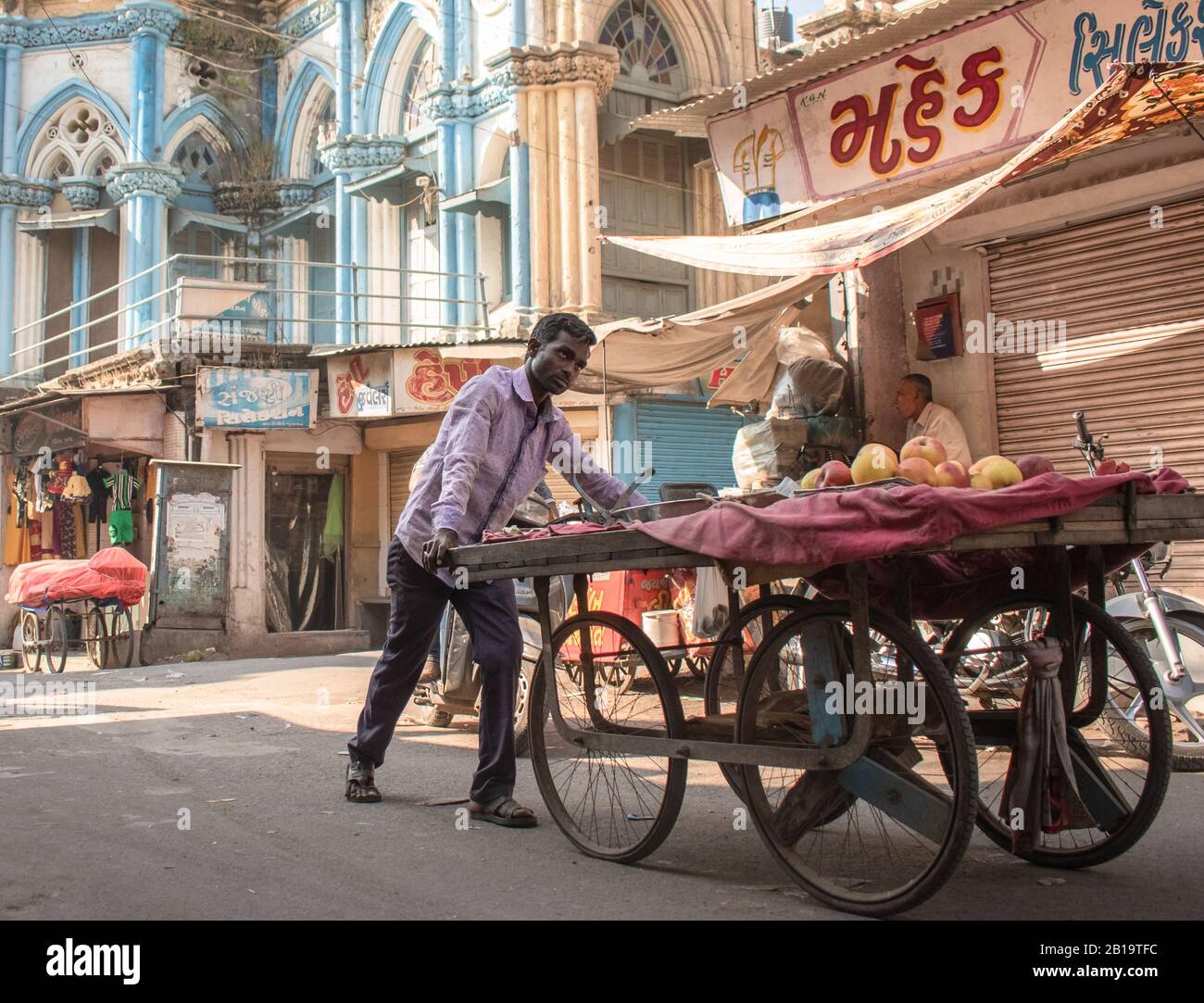 Junagadh, Gujarat/Inde - décembre 7 2018 : un vendeur pousse sa charrette à fruits dans la rue du marché autour de Circle Chowk à Junagadh. Banque D'Images