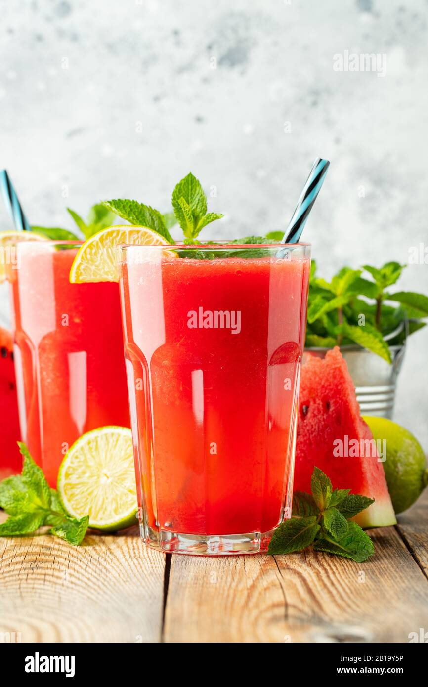 La sauce au melon d'eau avec citron vert et menthe, une boisson rafraîchissante d'été dans de grands verres sur fond bleu clair. Smoothie doux et froid Banque D'Images