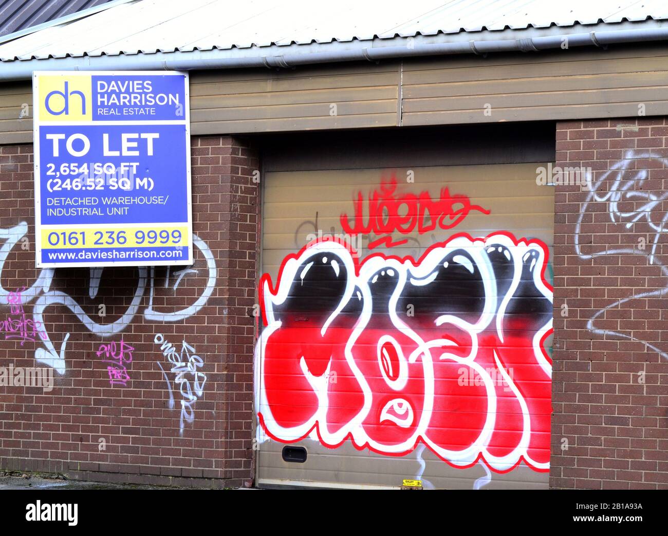 Graffiti sur un bâtiment commercial qui doit laisser dans le sud de Manchester. Banque D'Images