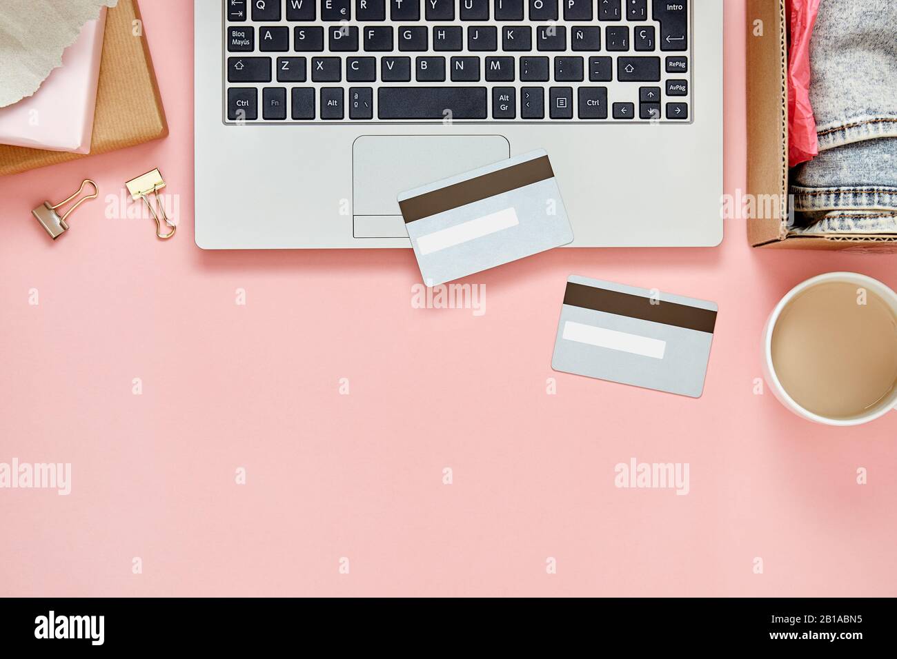 Concept de shopping en ligne sur table de bureau rose avec ordinateur portable, cartes de crédit, colis et espace de copie. Vue de dessus. Banque D'Images