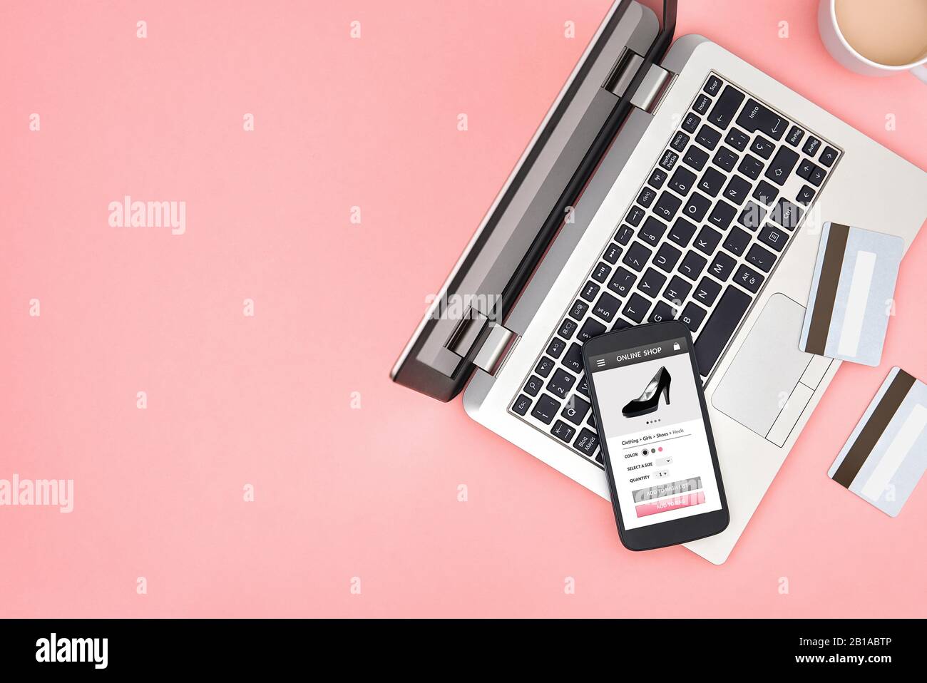 Boutique en ligne pour les femmes sur écran de smartphone sur fond rose avec ordinateur portable, cartes de crédit et espace de copie. Vue de dessus. Banque D'Images