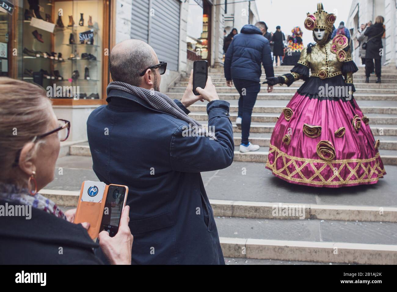 Un carnaval-goer vêtu de poses de costume pour les touristes à Venise Banque D'Images