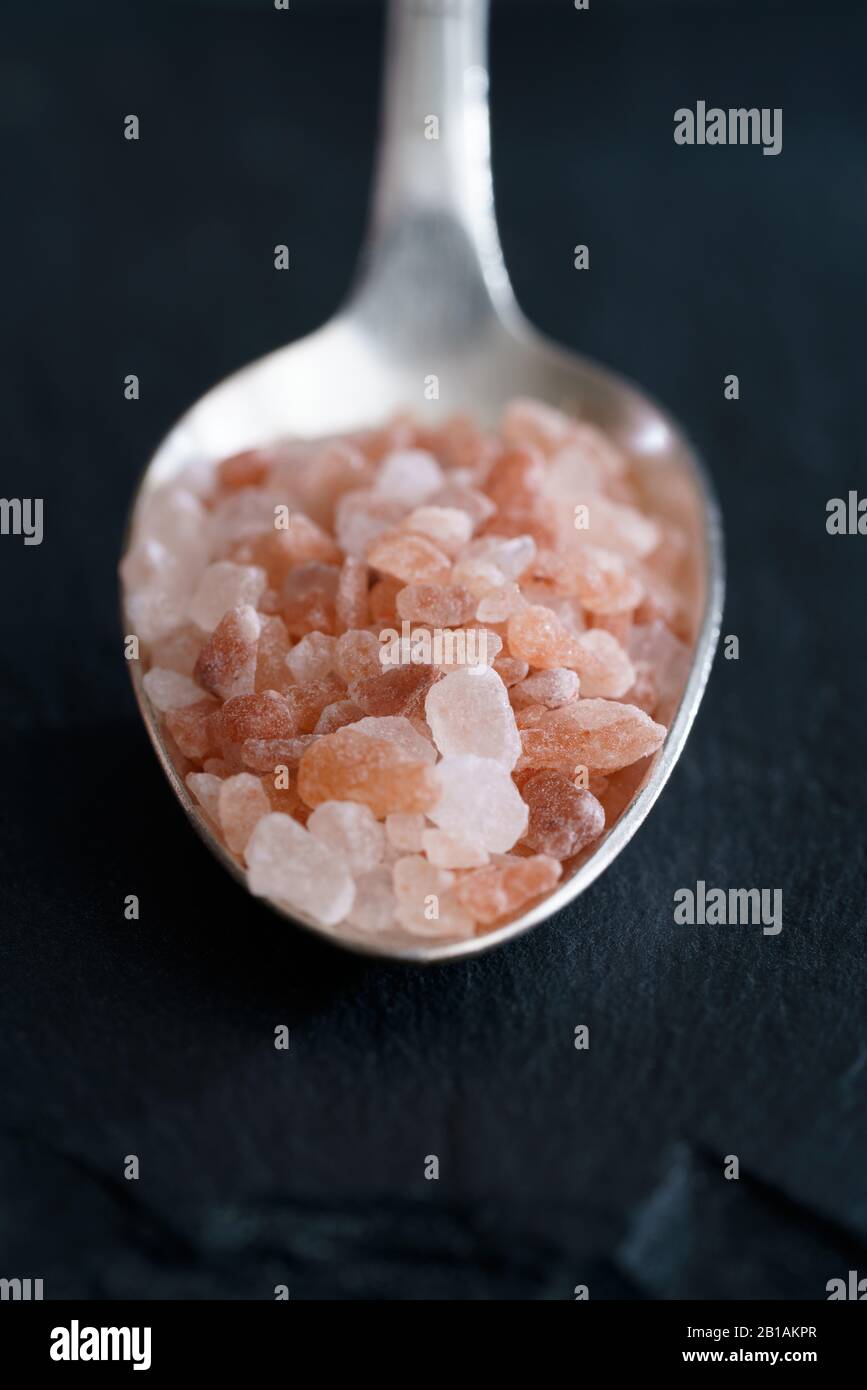 Prise de sel quotidienne, 1 cuillère à café de sel himalayen rose. Fond noir, haute résolution, lumière dure Banque D'Images