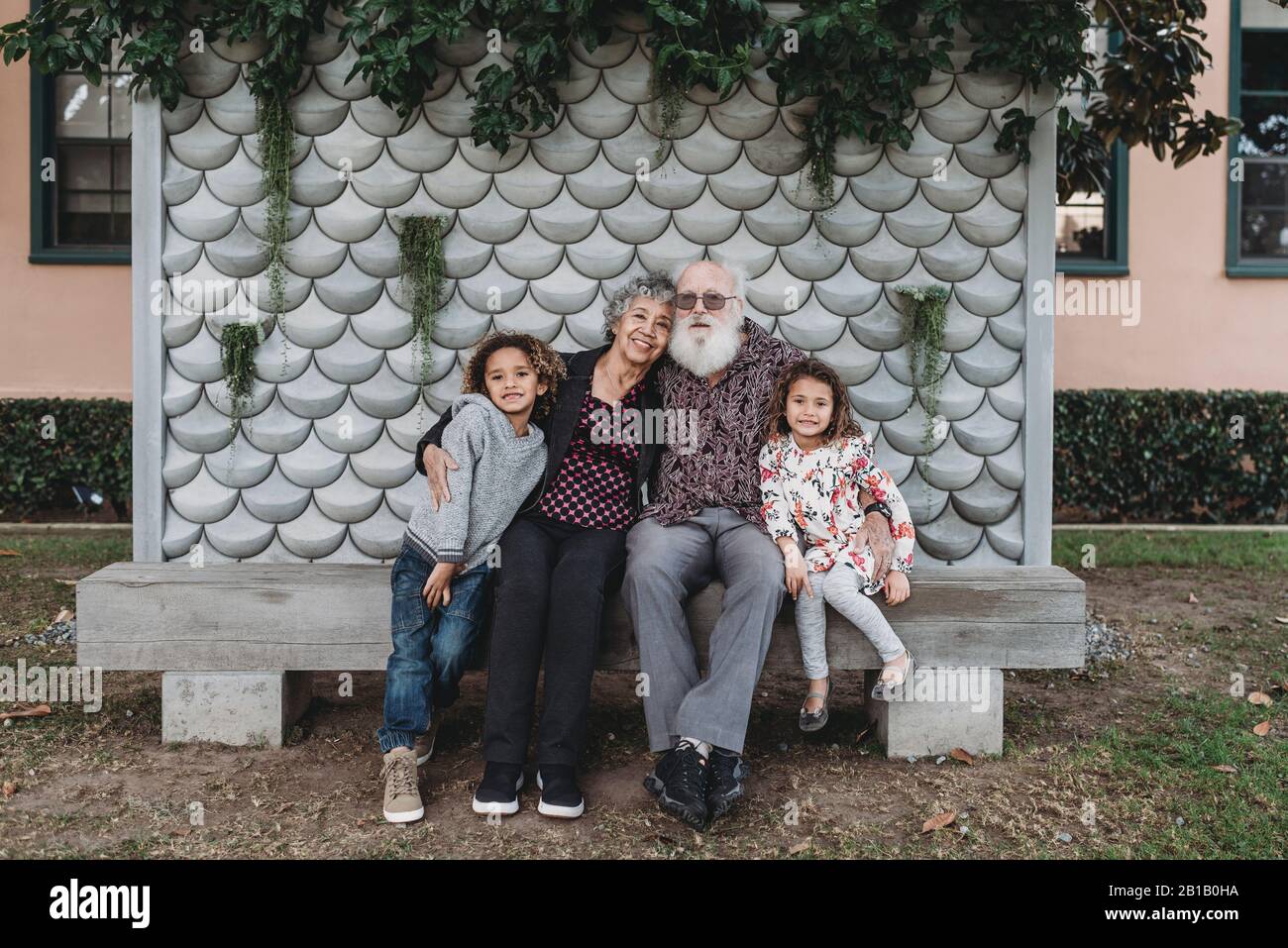 Portrait de grands-parents assis avec de jolis petits-enfants jumeaux à l'extérieur Banque D'Images