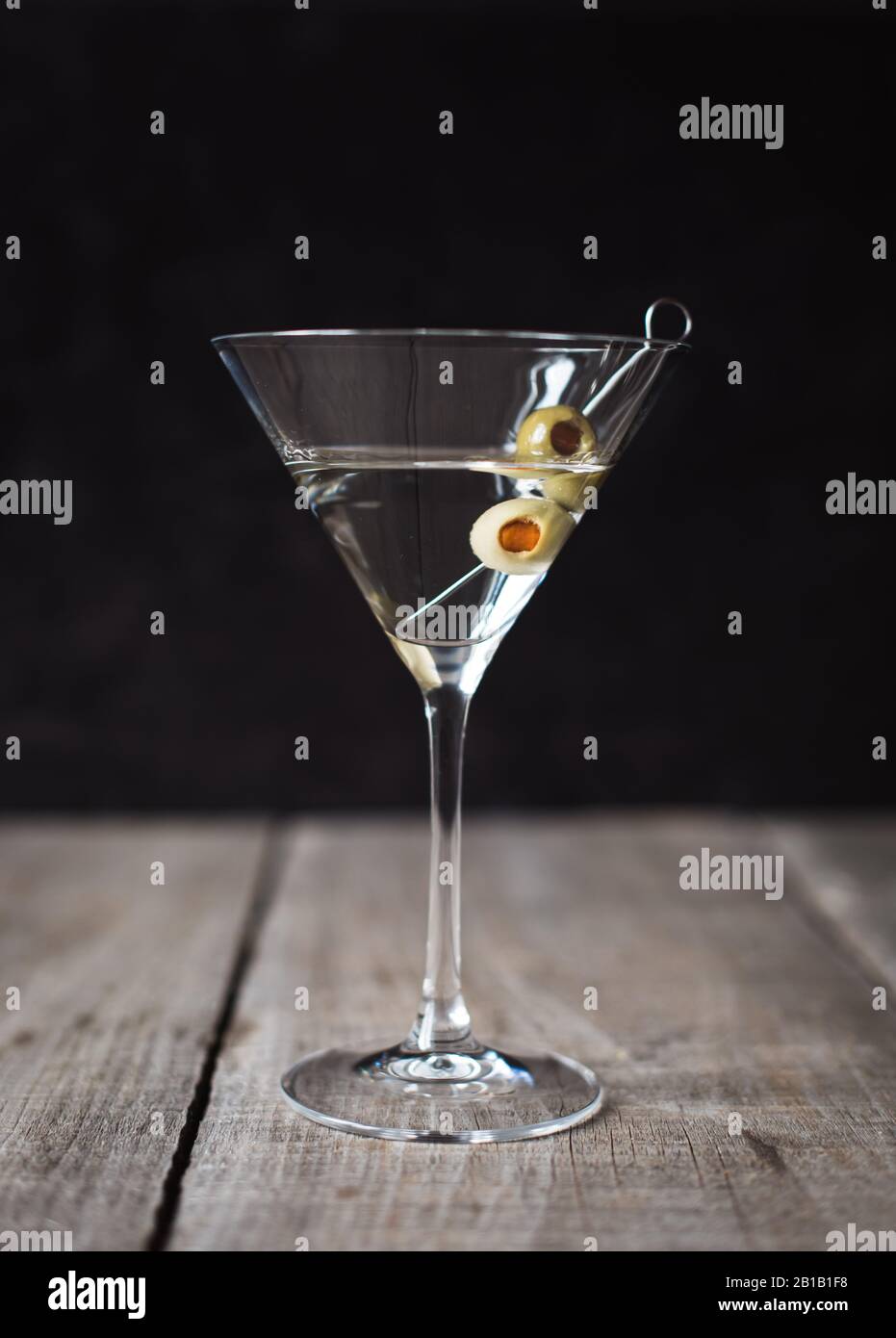 Gros plan d'un cocktail martini sur une table en bois avec fond noir. Banque D'Images