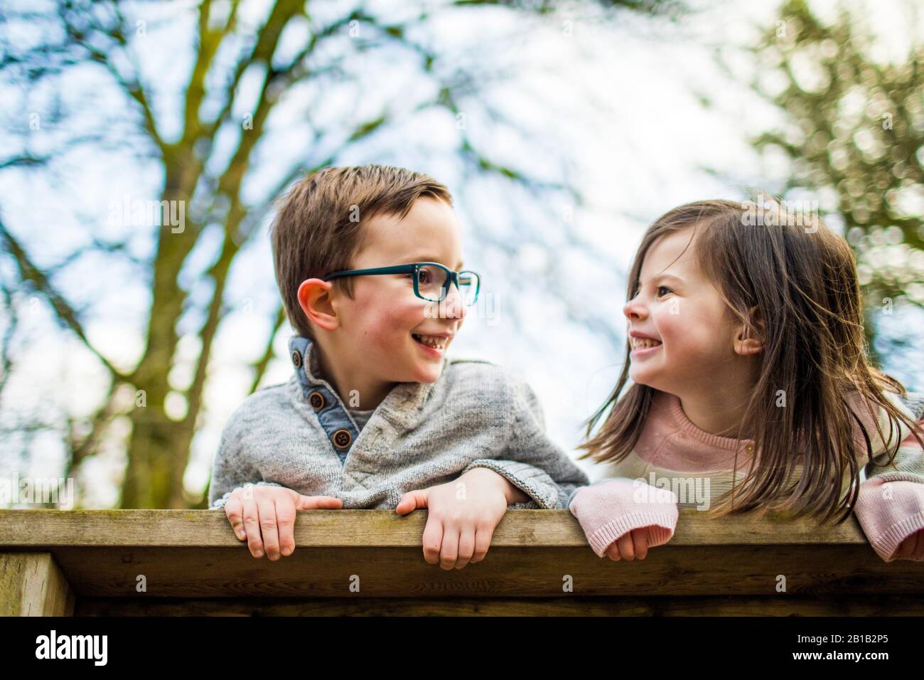 Portrait ludique de garçon et de fille sur rail. Banque D'Images