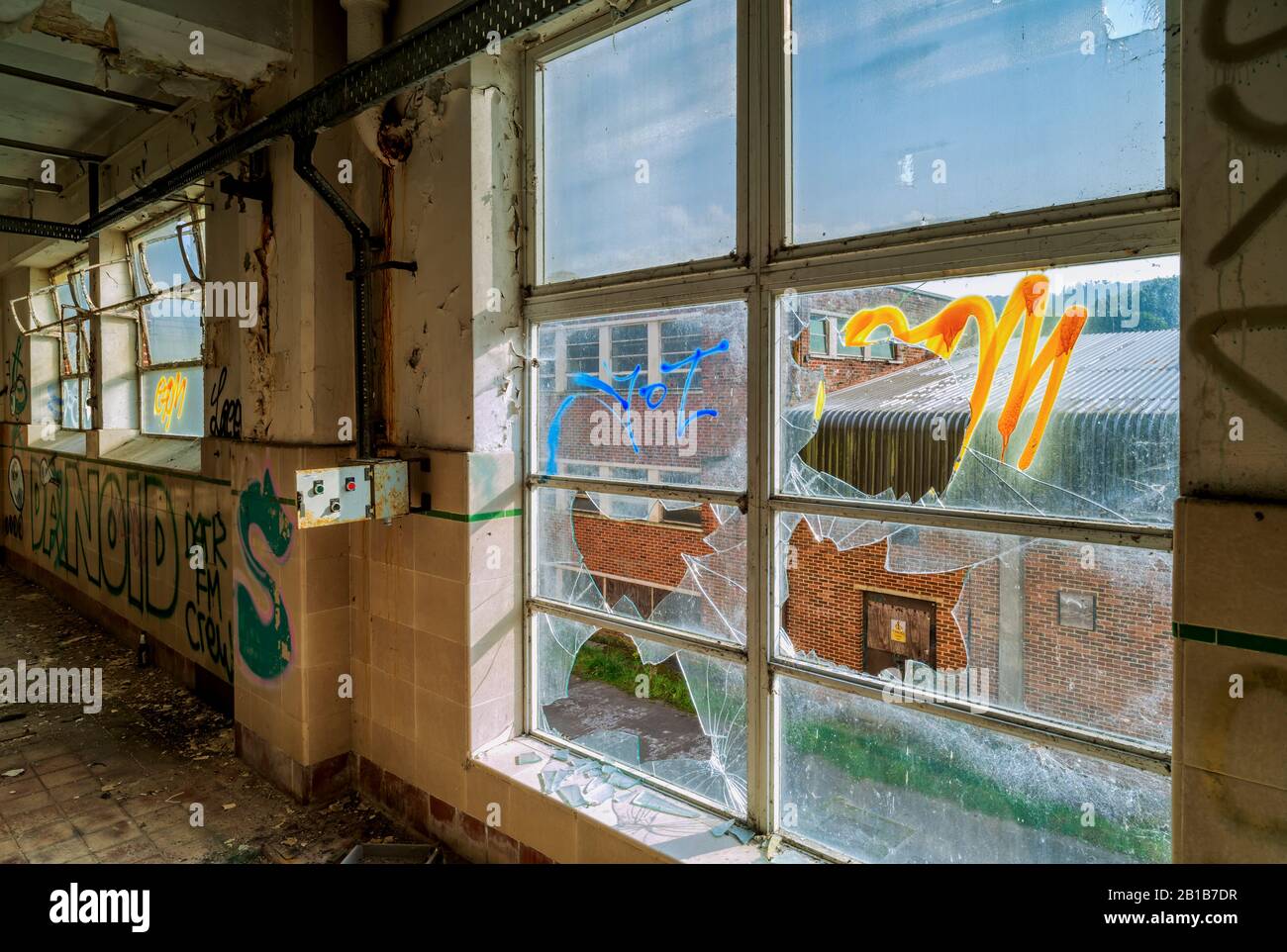 Les bâtiments urbains abandonnés et négligés, avec des graffitis et des fenêtres écrasées, désertés, oubliés, peuvent vaporiser de l'art Banque D'Images
