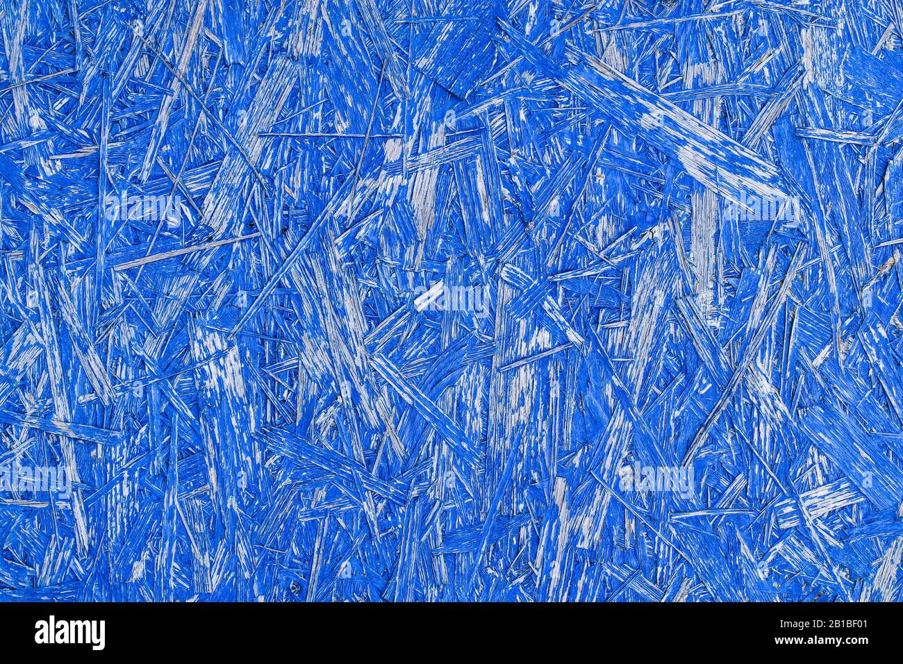 Fond bleu abstrait avec texture en bois. Panneau OSB peint. Vue détaillée du matériau de construction de panneaux de particules de bois en bleu vif Banque D'Images