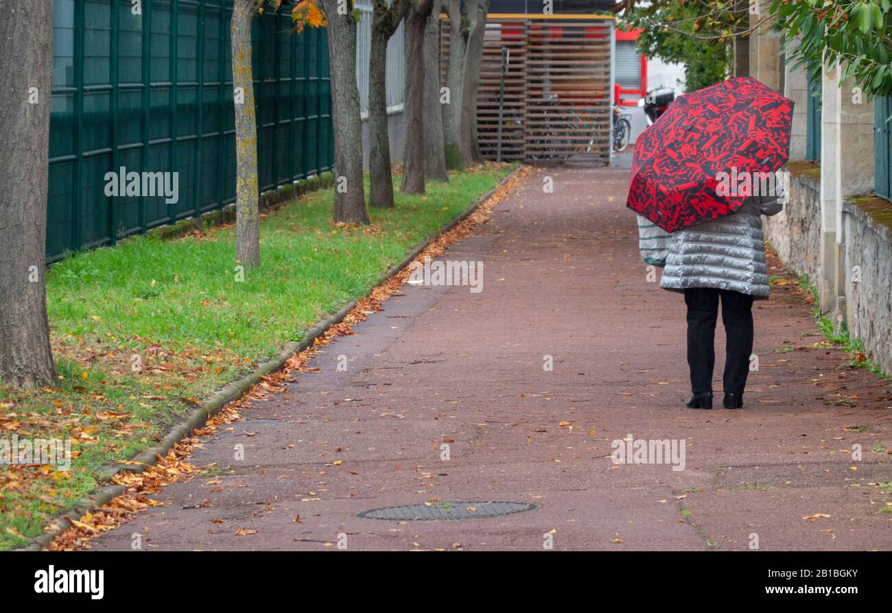Femme marchant dans une allée Paris France Banque D'Images