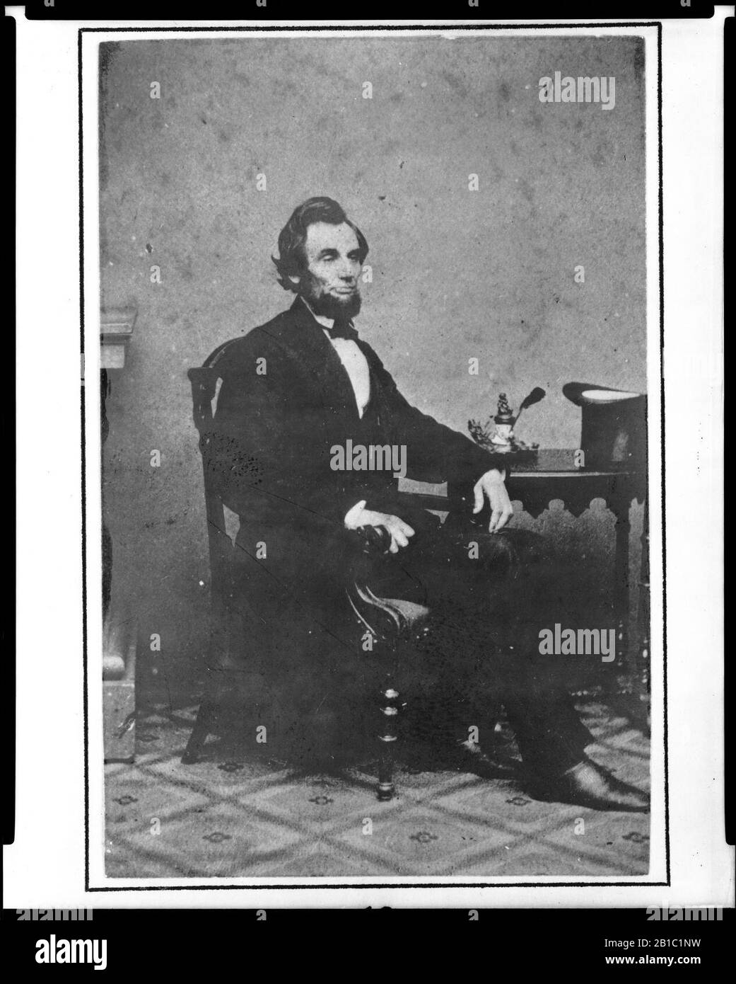 Portrait complet du président Abraham Lincoln assis à côté de la petite table, 24 février 1861 Banque D'Images