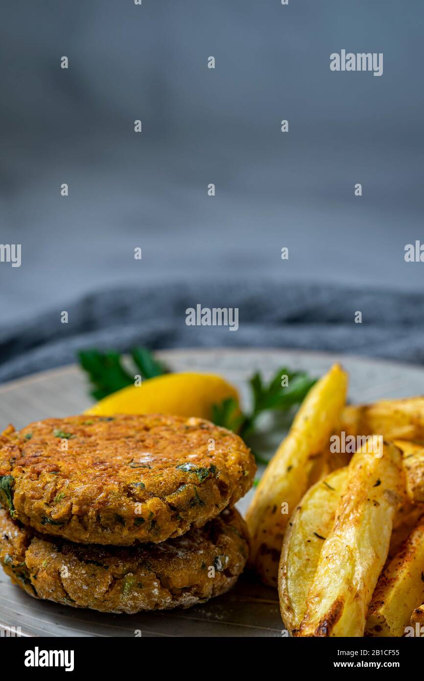 Patties de pois chiches végétaliens avec frites au four. Banque D'Images