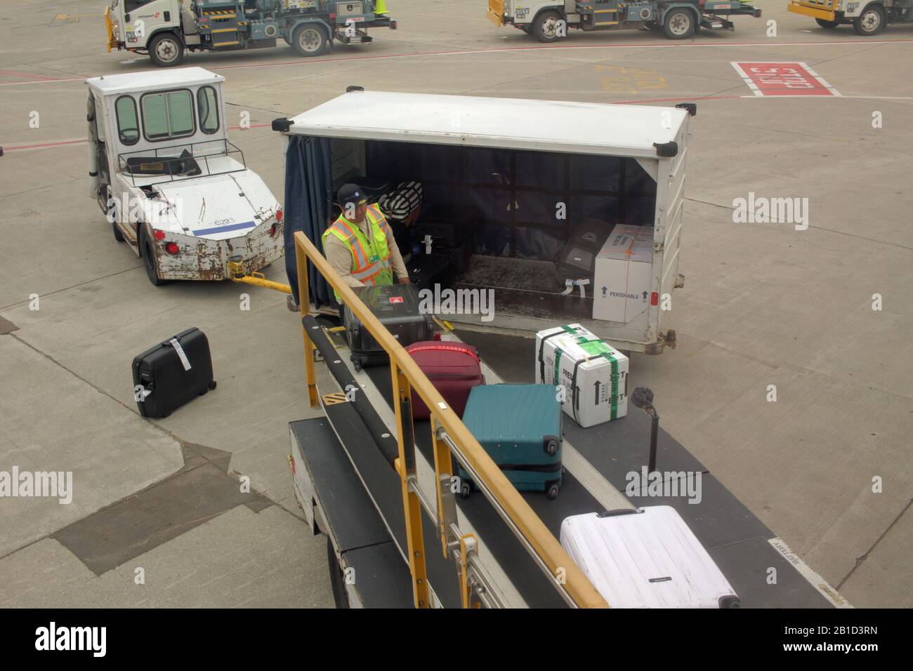 Le gestionnaire de bagages de l'aéroport déchargera les bagages d'un avion à l'aéroport de Chicago O'Hare, aux États-Unis Banque D'Images