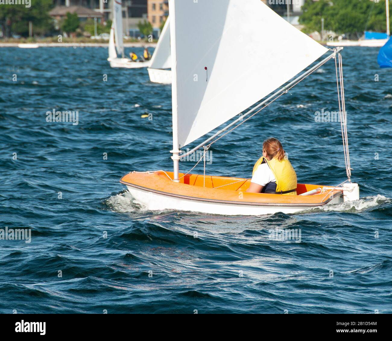 Enfant naviguant dans un petit bateau et en compétition. Travail d'équipe par des marins juniors en course sur le lac d'eau salée Macquarie. Photo à usage commercial. Banque D'Images