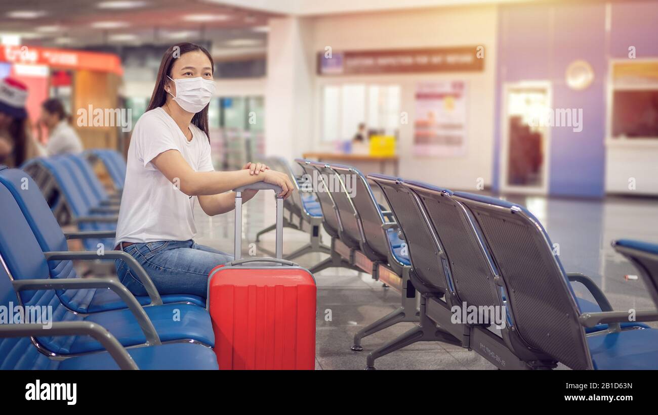 Touriste asiatique avec bagages, portant un masque hygiénique pour empêcher pendant le voyage au terminal de l'aéroport de se protéger du Coronavirus 2019 (COVID-1 Banque D'Images