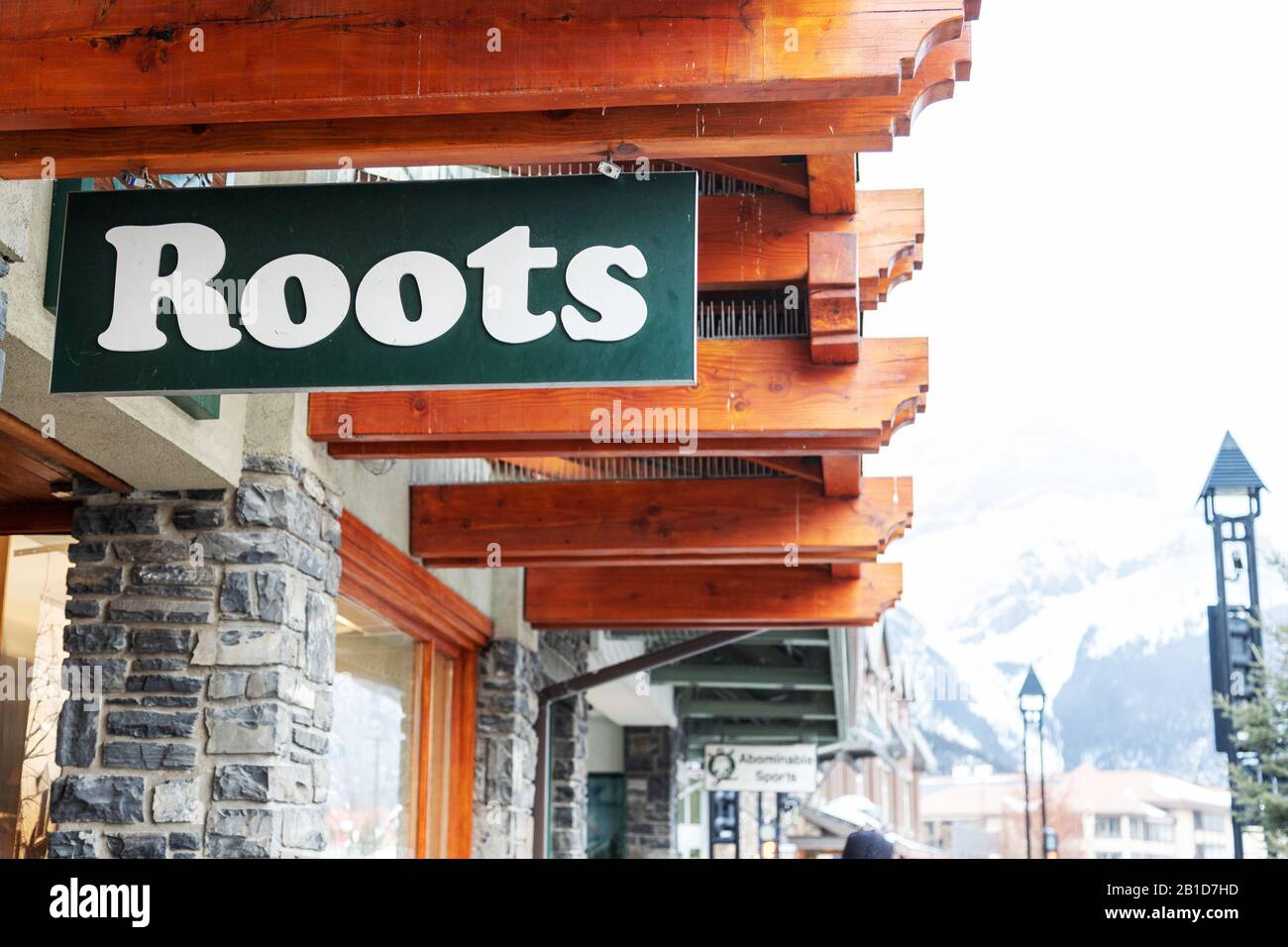 Banff, CANADA - 15 FÉVRIER 2020 : magasin Roots avec son panneau sur l'avenue Banff, très fréquentée, en Alberta, au Canada. Racines est une marque canadienne publique qui vend un Banque D'Images