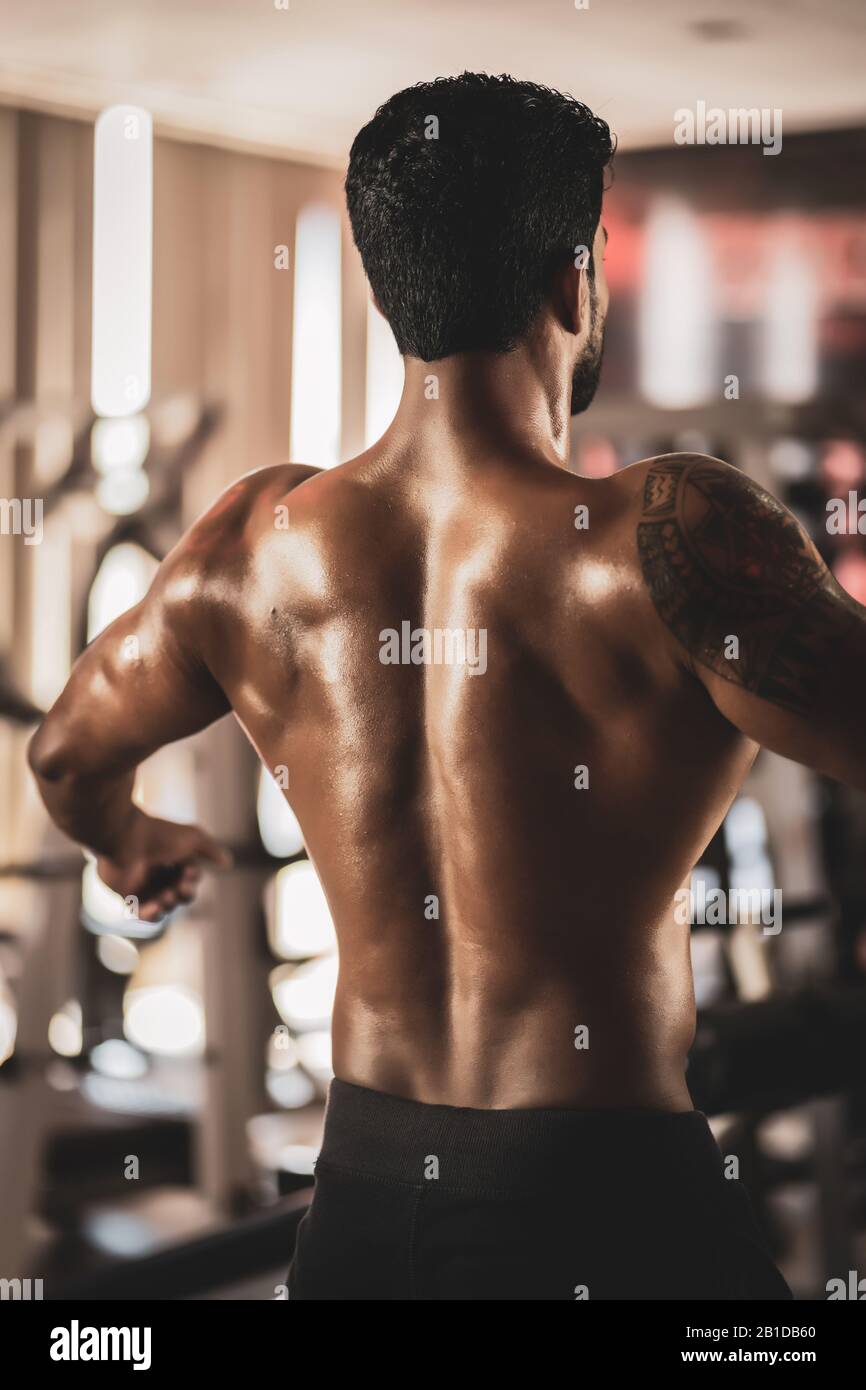 Un gars du culturisme musculaire debout sur la salle de gym et posant des muscles abdominaux Banque D'Images