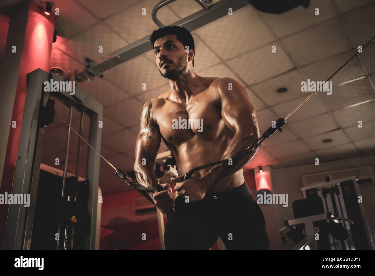 Bodybuilder musculaire aux crossover de câble des hommes de fitness pompant les muscles Banque D'Images